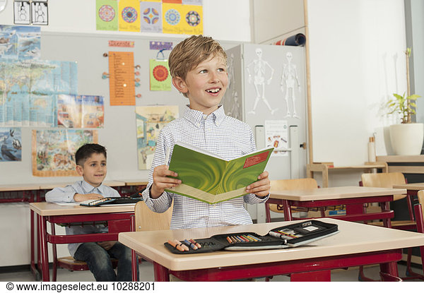 Schoolboy reading a book in classroom  Munich  Bavaria  Germany