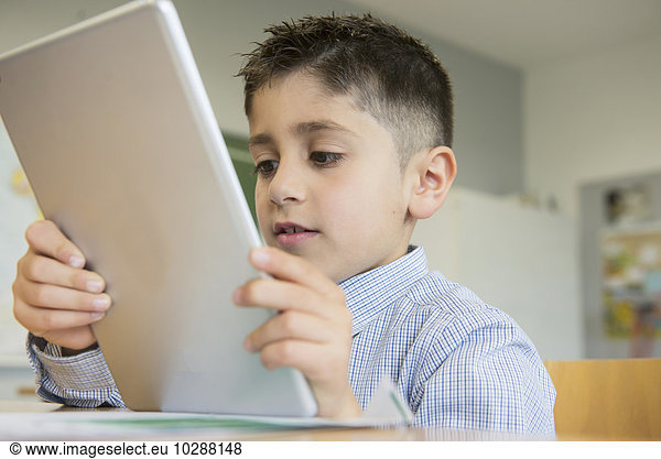 Schoolboy using a digital tablet in classroom  Munich  Bavaria  Germany