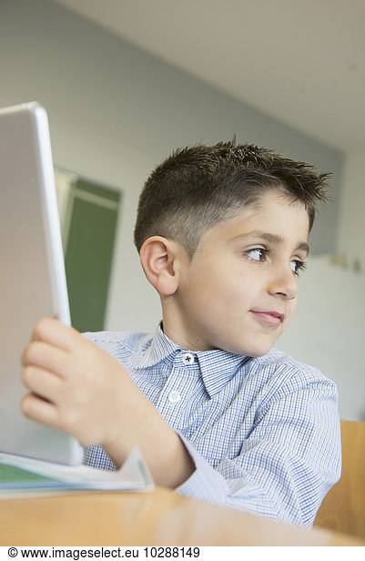 Schoolboy using a digital tablet in classroom  Munich  Bavaria  Germany