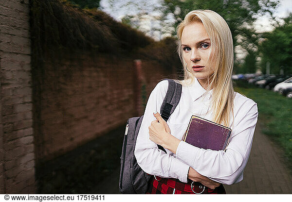 Schoolgirl walks with a book in her hands