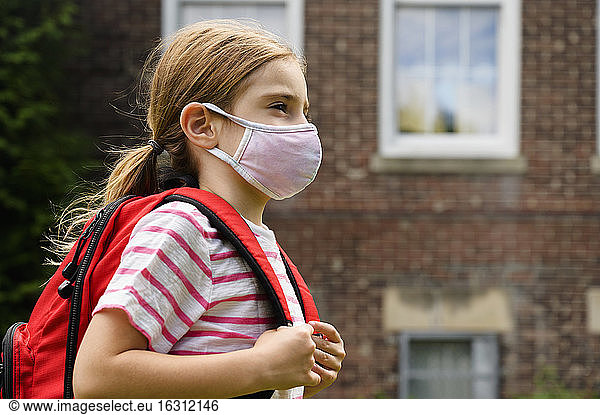 Schoolgirl (6-7) wearing flu mask