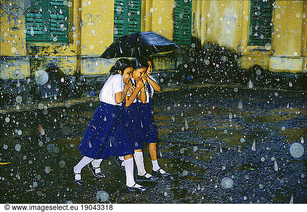 Schoolgirls in monsoon shower