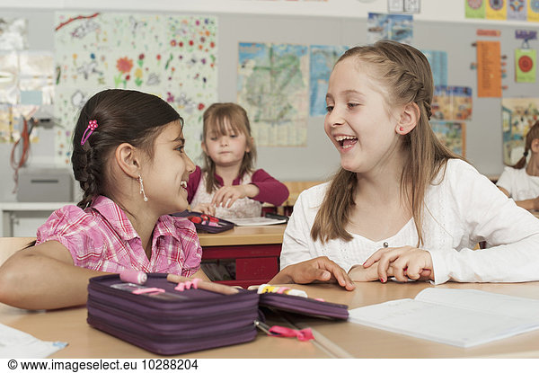 Schoolgirls talking in classroom  Munich  Bavaria  Germany