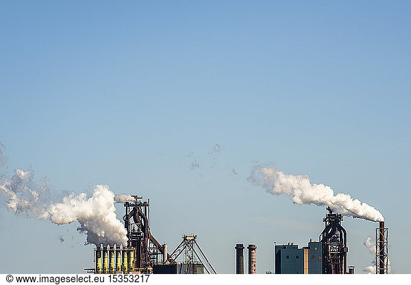 Schornsteine von Hochöfen der Stahlindustrie gegen den blauen Himmel  Niederlande
