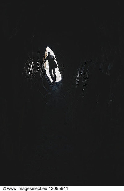 Schrägansicht eines in der Höhle von Pisac stehenden Scherenschnittwanderers
