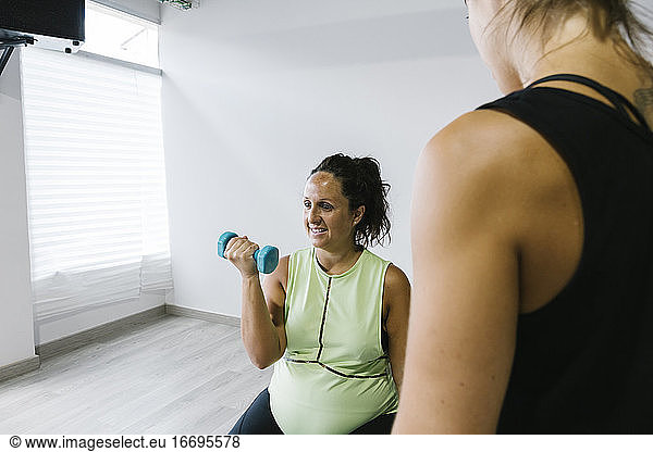 Schwangere Frau beim Krafttraining im Fitnessstudio