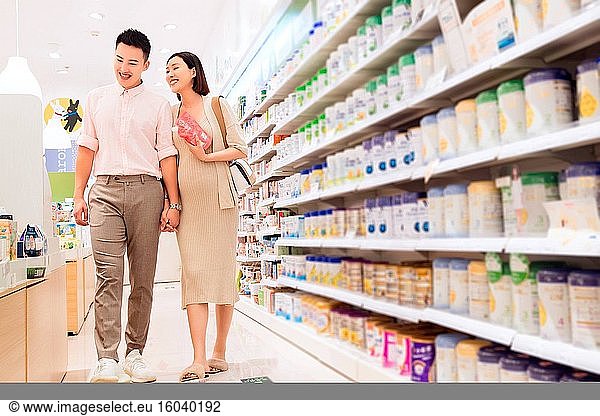 Schwangere Frau und ihr Mann beim Einkaufen im Supermarkt