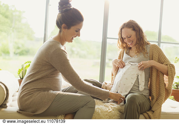 Schwangere Frauen  die sich Babykleidung ansehen