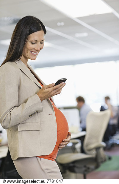 Schwangere Geschäftsfrau mit Handy