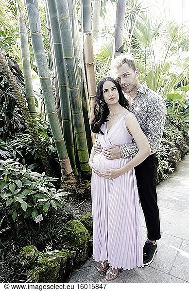 Schwangeres Paar im botanischen Garten