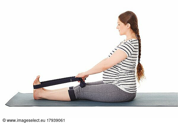Schwangerschaft Yoga-Übung  schwangere Frau  die Yoga asana Dandasana Staff Pose mit Yoga-Gurt vor weißem Hintergrund