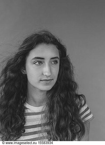 Schwarz-Weiß-Porträt eines hübschen sechzehnjährigen Mädchens  Wind weht durch langes gewelltes Haar