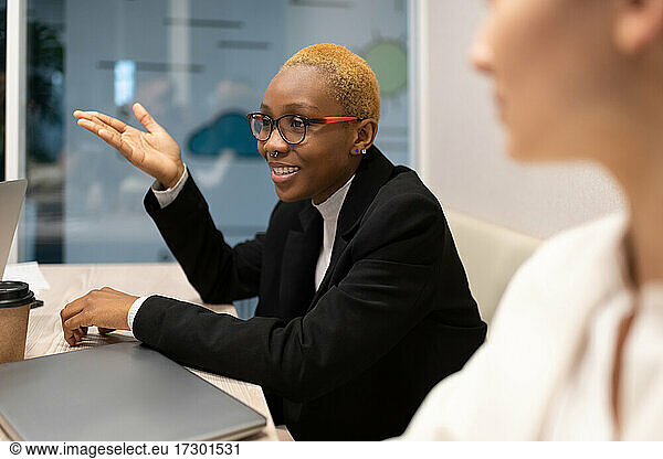 Schwarze Geschäftsfrau im Gespräch mit Kollegen während einer Besprechung
