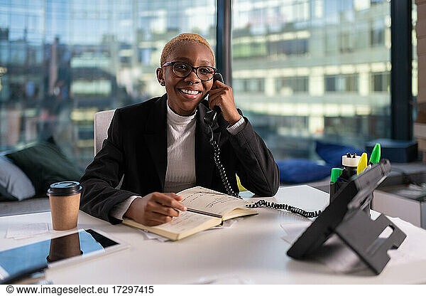 Schwarze Geschäftsfrau nimmt Telefonanruf entgegen