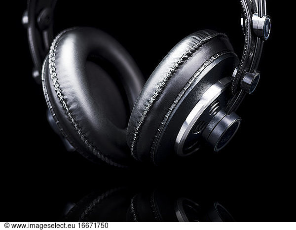 Schwarze Hi-Fi-Kopfhörer über einer schwarzen reflektierenden Oberfläche