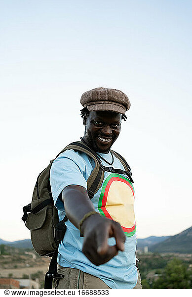 schwarzer afroamerikanischer Mann mit grünem Rucksack  Reisekonzept
