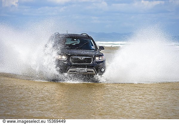 Schwarzer Hyundai Santa Fe 4x4 SUV fährt am Strand von Ninety Mile Beach im Wasser Far North District Northland Nordinsel Neuseeland Ozeanien