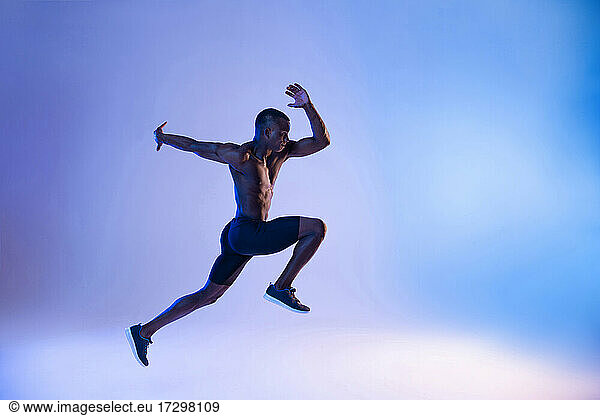 Schwarzer Sportler springt im Studio