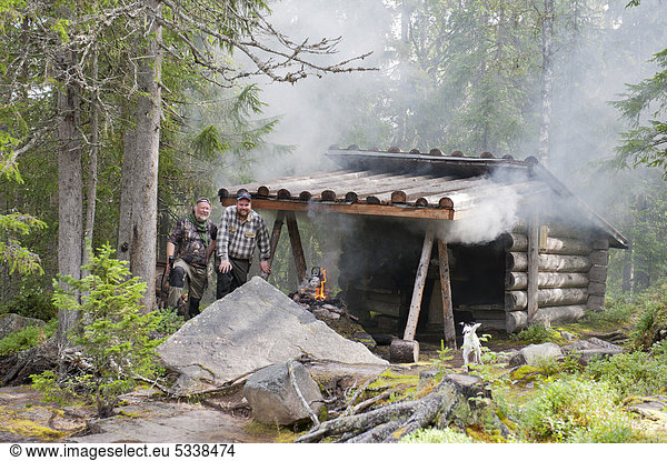 Schwedischer Waldarbeiter und schwedischer Jäger kochen Kaffee auf Feuer in einer Hütte im Wald,  beim Fulufjällets Nationalpark,  Tjärnvallen bei Särna,  Provinz Dalarna,  Schweden,  Skandinavien,  Nordeuropa,  Europa