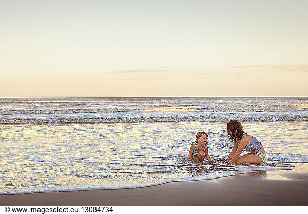 Schwester genießt am Strand am Strand während des Sonnenuntergangs