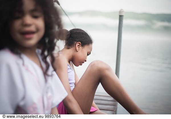 Schwestern  die im Sommerurlaub am Lake George  New York  USA  am Dock sitzen