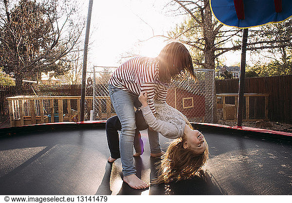 Schwestern spielen auf dem Spielplatz Trampolin