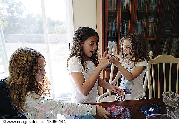 Schwestern spielen zu Hause mit Ton am Tisch