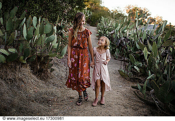 Schwestern wandern Hand in Hand durch den Wüstengarten in San Diego
