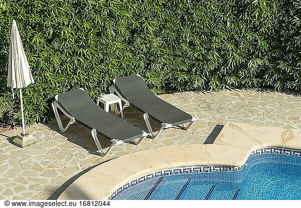 Schwimmbad mit ein paar schwarzen Liegen in einer mediterranen Villa in Alicante  Spanien.