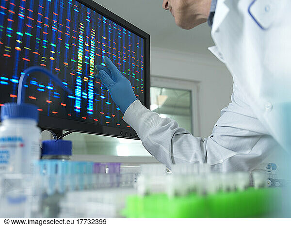 Scientist analyzing DNA on computer screen at laboratory