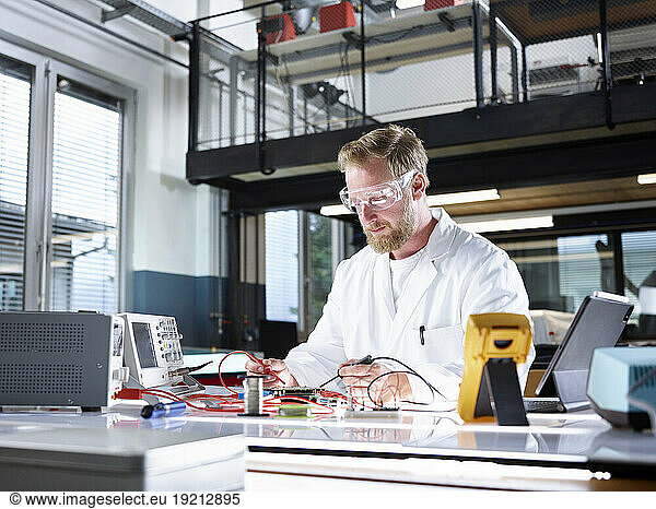 Scientist examining and working on electrometer in laboratory