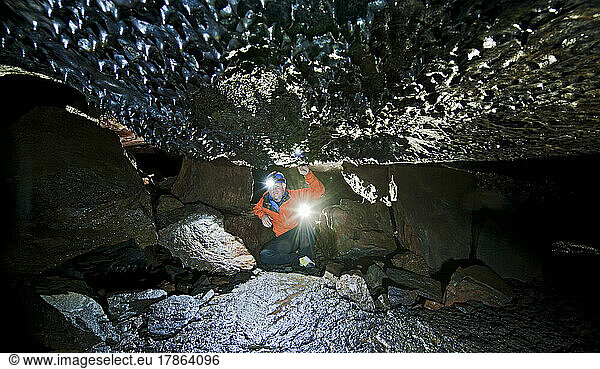 scientist exploring the Leidarendi lava cave in Iceland