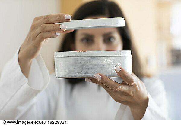 Scientist holding metal box  focus on foreground