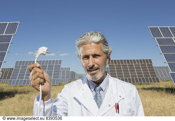 Scientist holding plug to solar panels