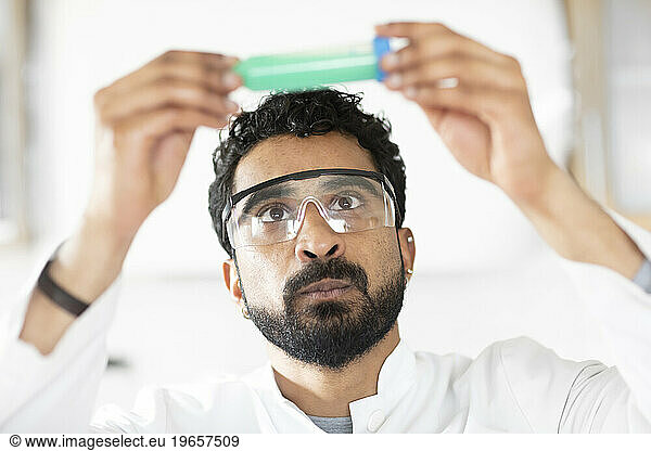 scientist male with beard looking to a sample