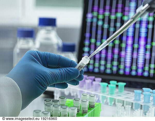 Scientist pipetting DNA sample into vial for testing