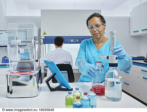 Scientist preparing chemical at desk in microbiological laboratory
