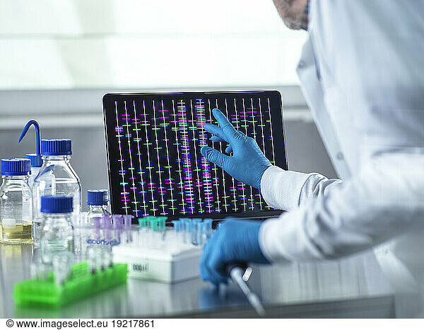Scientist using laptop for genetic research in laboratory
