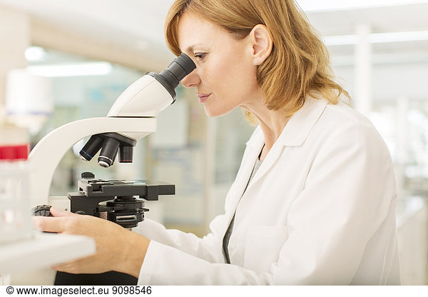 Scientist using microscope in laboratory