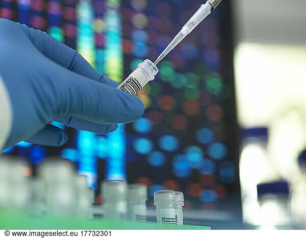 Scientist with pipette evaluating samples in test tube at laboratory