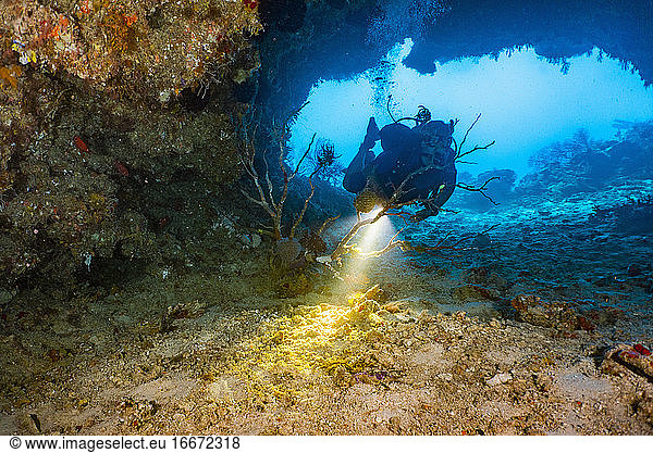 Scuba diver exploring cave at the Great Barrier Reef