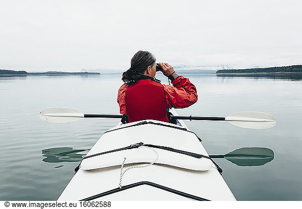 Sea kayakers looking at nautical chart and mapan inlet on the Alaska coastline.