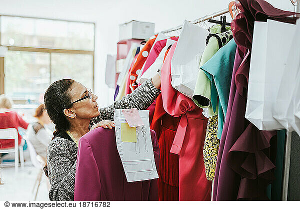 seamstress placing clothes in the design studio