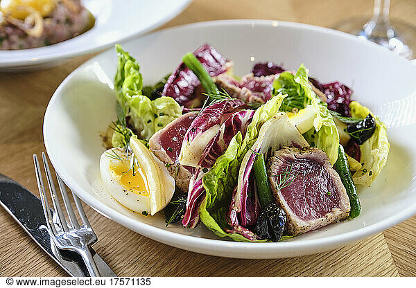 Seared ahi tuna salad with mixed greens and red wine.