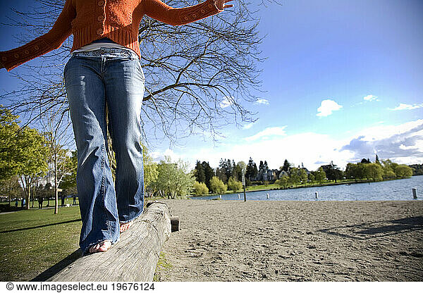 SEATTLE  WASHINGTON. A girl balances on a log next to Greenlake in Seattle  Washington.