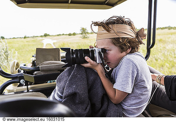 Sechsjähriger Junge fotografiert aus Safari-Fahrzeug  Botswana