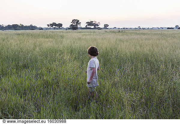 Sechsjähriger Junge im Grasfeld  Botswana