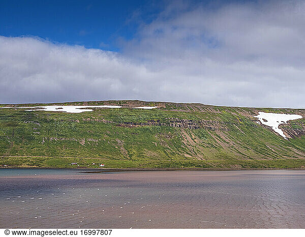 Secluded farm at foot of coastal hill in Westfjords