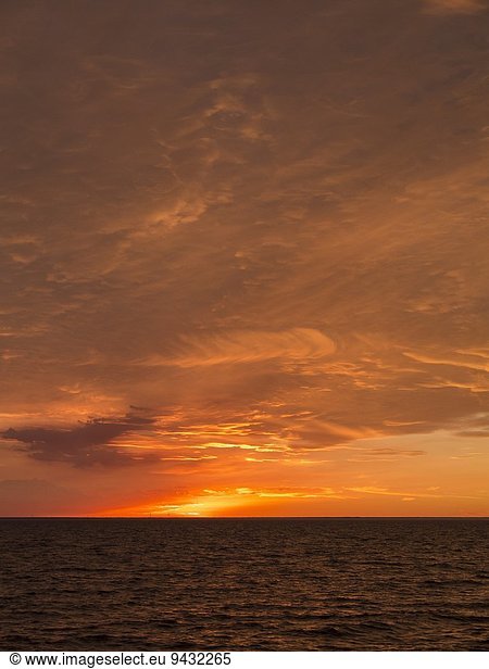 Seelandschaft mit Sonnenuntergang über dem Horizont