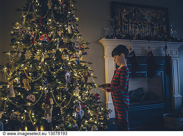 Seitenansicht des Jungen beim Betrachten des beleuchteten Weihnachtsbaums